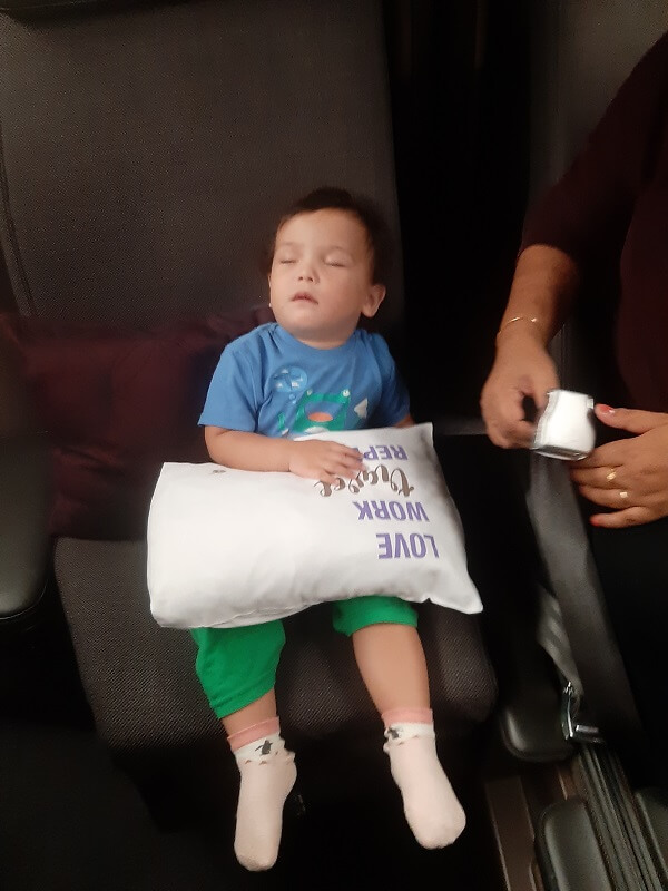 Toddler Leila asleep in airplane seat