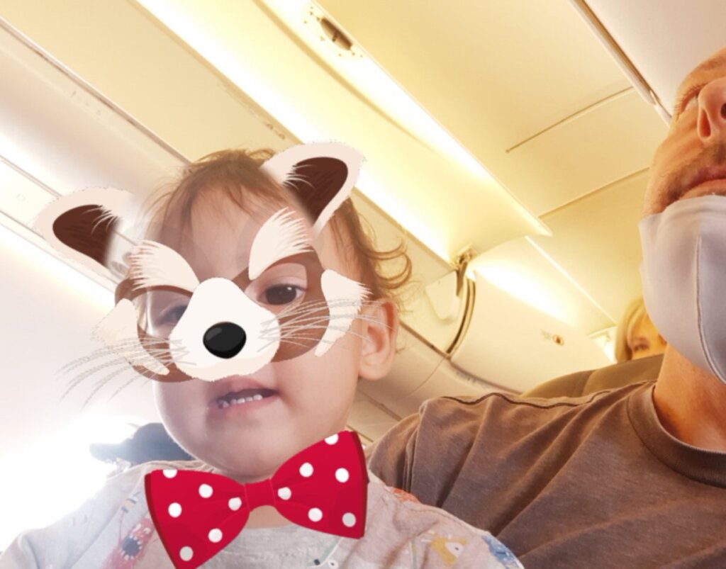 Father and daughter in airplane seat making silly face