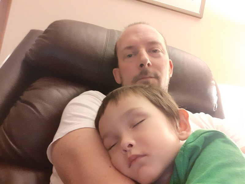 Adam sleeping on author's lap in recliner chair