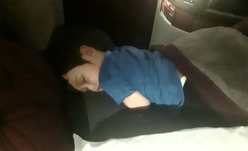Toddler Adam sleeping in airplane seat