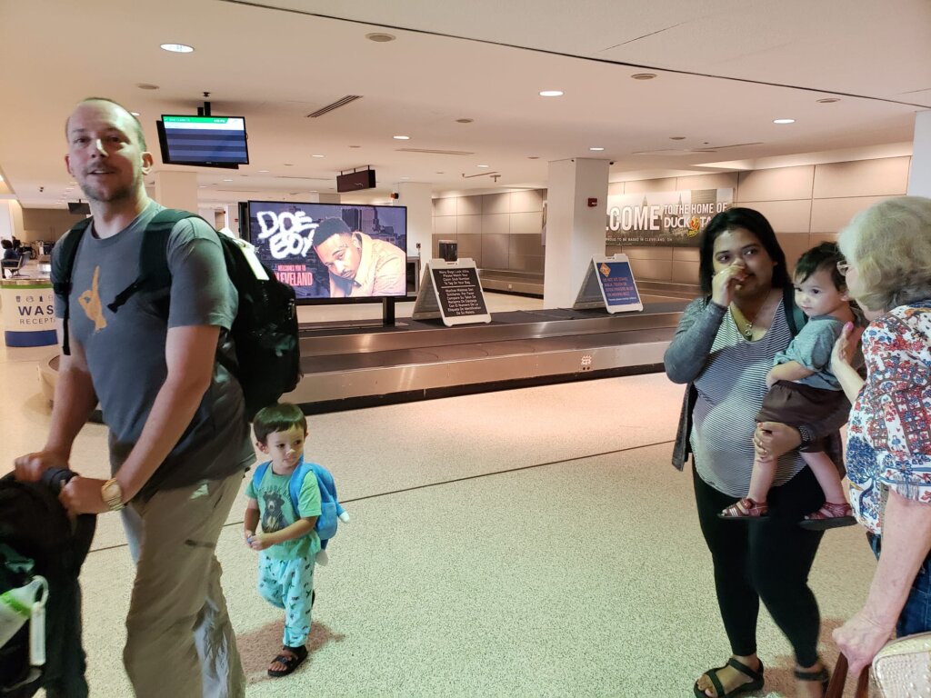 Family walking through baggage claim area at airport